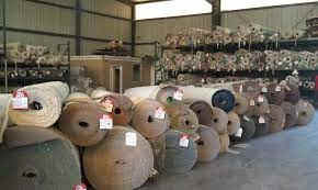 Rolls of carpet on racks in a carpet warehouse.