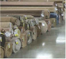 Rolls of carpet on display at a retail carpet warehouse.